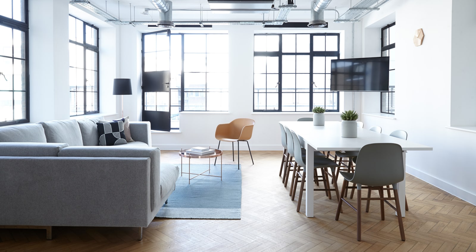 Helles Büro mit Sofa, Esstisch und Fischgrätparkett